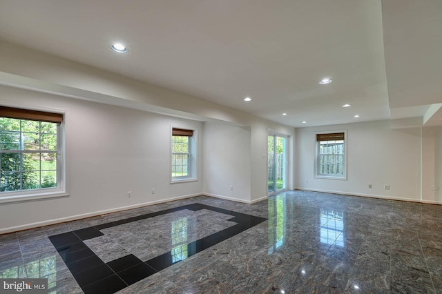 empty room with baseboards, recessed lighting, and granite floors