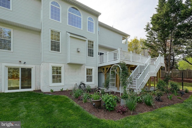 rear view of house featuring stairway and a deck