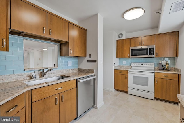 900 N Stafford St Unit 2330, Arlington, VA 22203 - kitchen with stainless steel appliances, a sink, decorative backsplash, and brown cabinetry