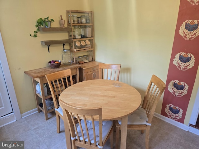 tiled dining room with baseboards