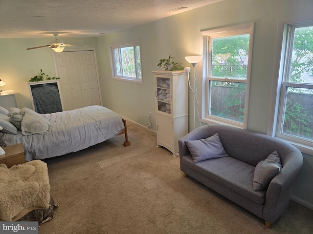 carpeted bedroom featuring a closet, a textured ceiling, and baseboards