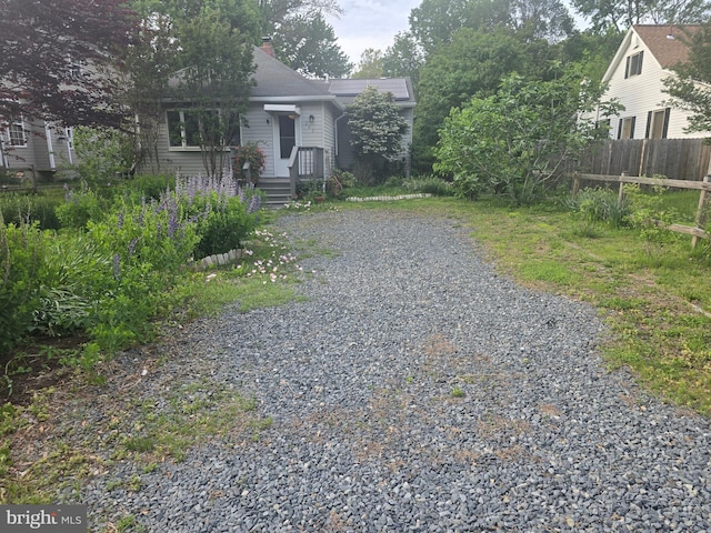view of yard with fence and gravel driveway
