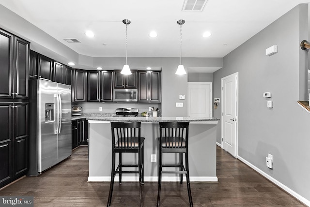 7471 Brunson Cir Unit 10A, Gainesville, VA 20155 - kitchen with stainless steel appliances, dark wood-type flooring, a kitchen breakfast bar, a kitchen island, and recessed lighting