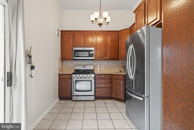 100 Furnlea Dr, Glen Burnie, MD 21060 - kitchen with appliances with stainless steel finishes, a chandelier, light tile patterned floors, decorative backsplash, and brown cabinets