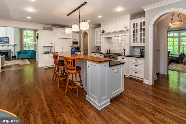 kitchen with ornamental molding, appliances with stainless steel finishes, and arched walkways