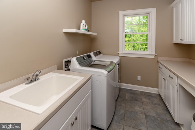 laundry room featuring cabinet space, separate washer and dryer, baseboards, and a sink