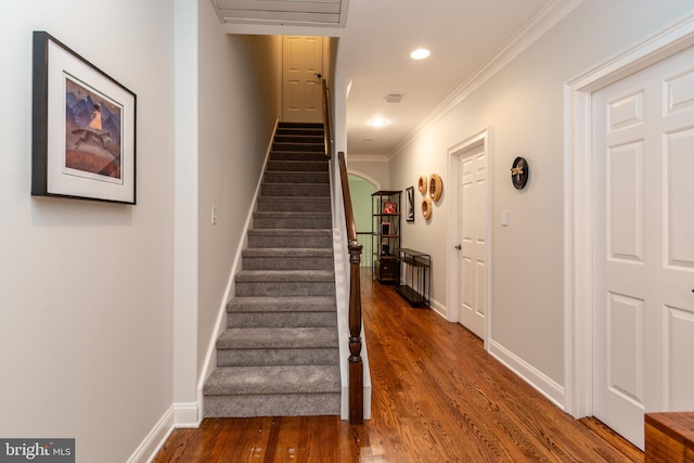 stairs with recessed lighting, baseboards, ornamental molding, wood finished floors, and arched walkways