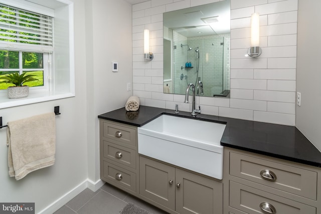 full bath featuring baseboards, a shower stall, tile patterned floors, vanity, and backsplash