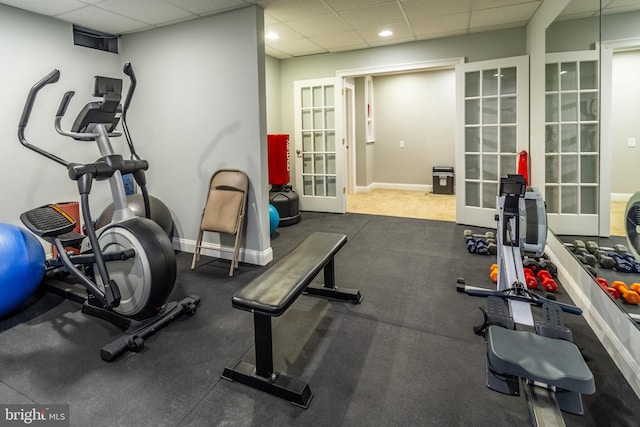 exercise area with french doors, baseboards, and a paneled ceiling