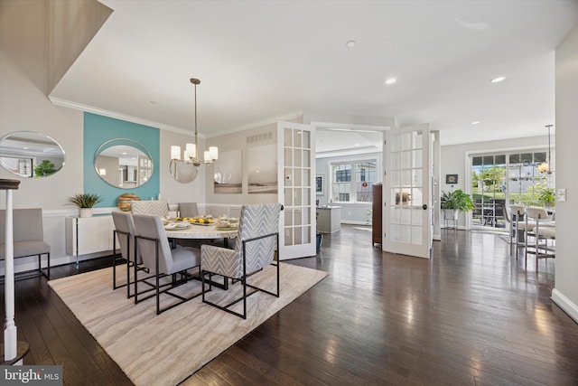 dining room with wood-type flooring, ornamental molding, visible vents, french doors, and a notable chandelier