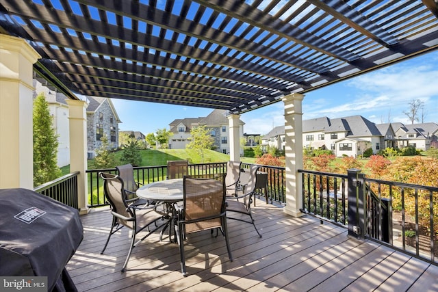 wooden terrace featuring a residential view, outdoor dining space, a yard, and a pergola