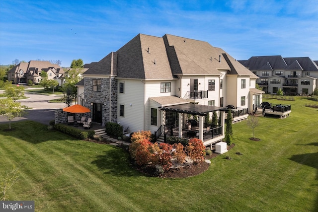 rear view of property with a lawn, a residential view, a pergola, and a deck