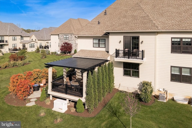 back of property with roof with shingles, a residential view, cooling unit, a balcony, and a yard