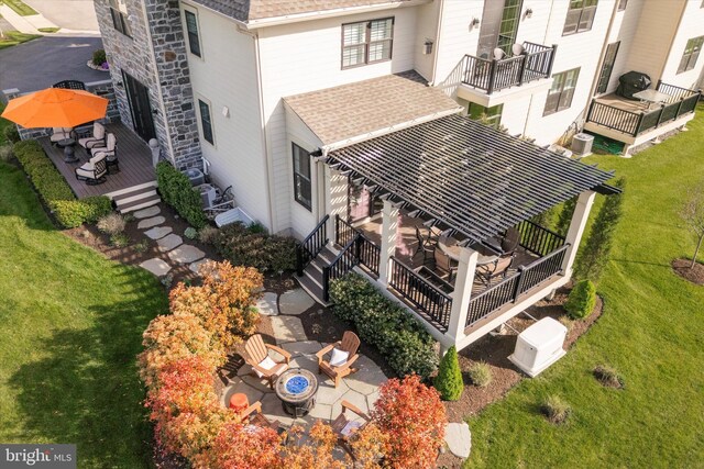 exterior details featuring roof with shingles, an outdoor fire pit, central AC, gutters, and a downspout