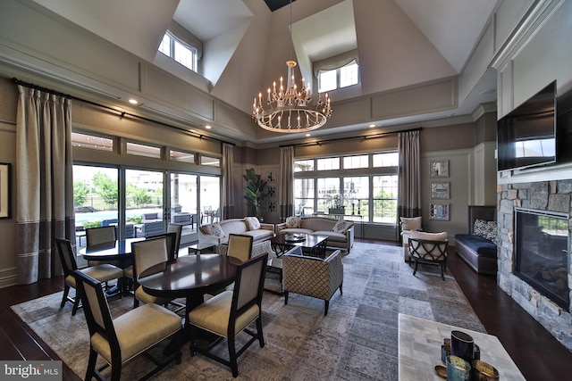 dining room with a high ceiling, a fireplace, and a notable chandelier