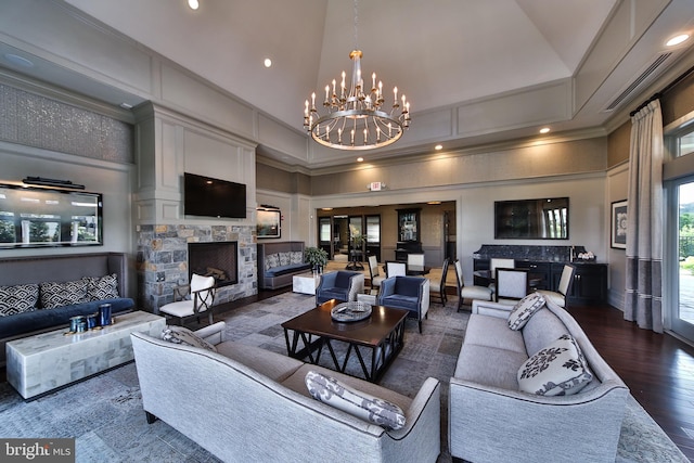 living area featuring a notable chandelier, high vaulted ceiling, a stone fireplace, recessed lighting, and wood finished floors