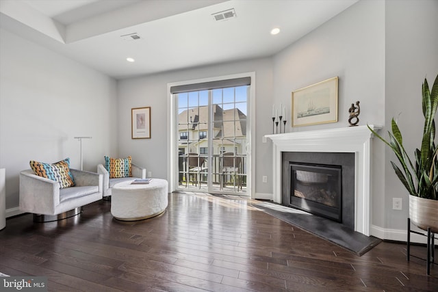 sitting room with recessed lighting, visible vents, a glass covered fireplace, and hardwood / wood-style flooring
