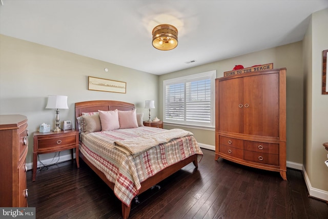 bedroom with baseboards, dark wood finished floors, and visible vents