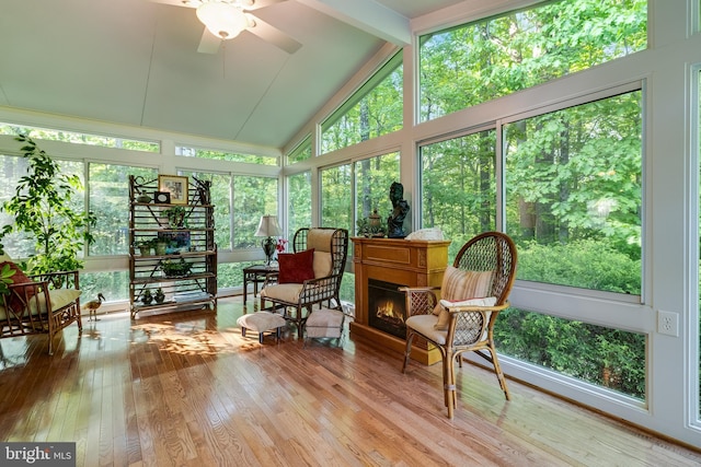 sunroom / solarium with high vaulted ceiling, wood-type flooring, and beam ceiling