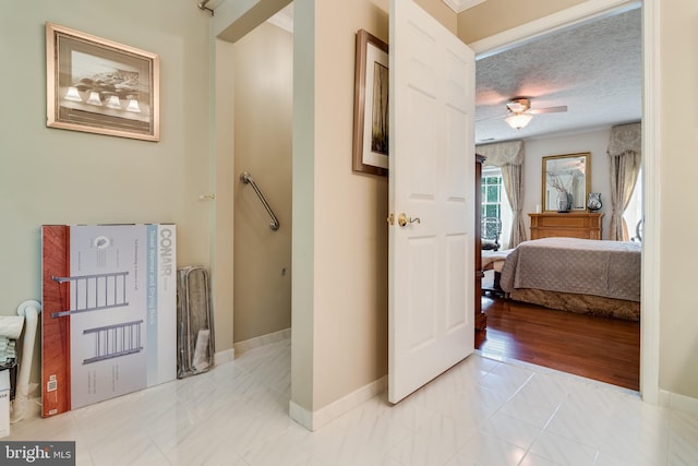 hall featuring baseboards and a textured ceiling