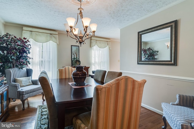 dining room with a chandelier, ornamental molding, and wood finished floors
