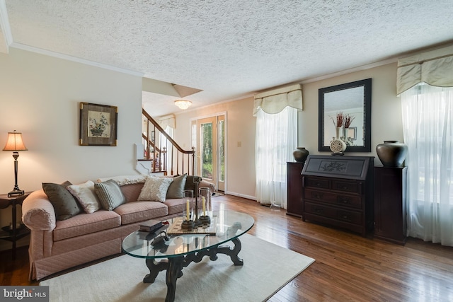 living area featuring crown molding, a textured ceiling, stairs, and wood finished floors