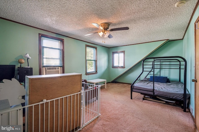 bedroom with ornamental molding, a textured ceiling, carpet floors, a ceiling fan, and baseboards