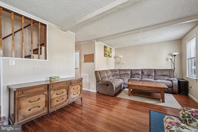 living room featuring a textured ceiling, visible vents, dark wood-style flooring, wooden walls, and baseboards