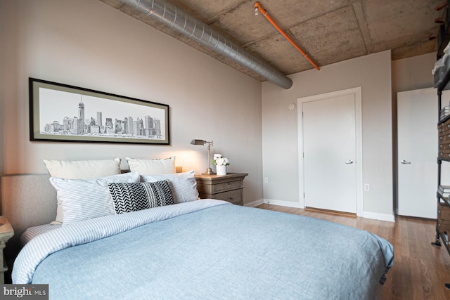 bedroom with baseboards and wood finished floors