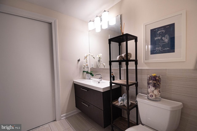 bathroom featuring vanity, tile patterned flooring, toilet, and tasteful backsplash