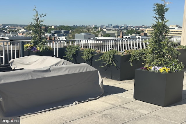view of patio / terrace with a view of city, fence, and a balcony