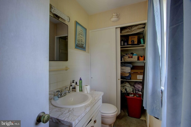 half bath featuring toilet, tasteful backsplash, and vanity