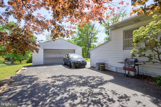 view of home's exterior with a detached garage and an outdoor structure