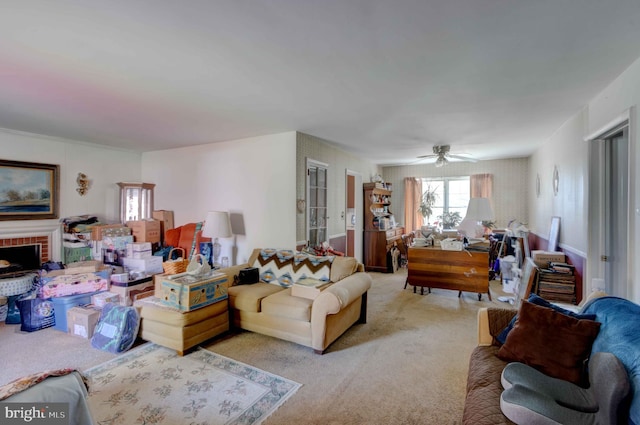 living area with light colored carpet, a brick fireplace, and ceiling fan