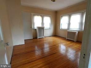4815 E Roosevelt Blvd, Philadelphia, PA 19124 - unfurnished room featuring ornamental molding, wood finished floors, and radiator