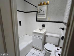 4815 E Roosevelt Blvd, Philadelphia, PA 19124 - full bathroom with vanity, toilet, tile walls, shower / bathing tub combination, and tile patterned floors