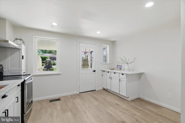 408 Fairview Ave, Lancaster, PA 17603 - kitchen with white cabinets, electric range, light wood-style floors, light countertops, and baseboards