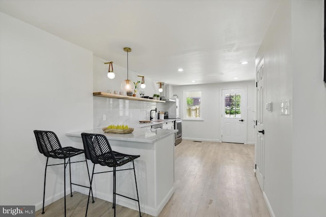 408 Fairview Ave, Lancaster, PA 17603 - kitchen featuring open shelves, decorative backsplash, a peninsula, light wood-type flooring, and light countertops
