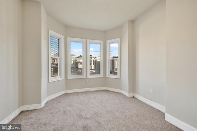 carpeted spare room with baseboards