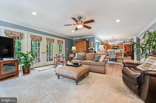 living area featuring french doors, ceiling fan with notable chandelier, light wood finished floors, ornamental molding, and recessed lighting