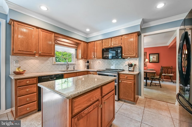 kitchen with a kitchen island, light stone counters, a sink, backsplash, and black appliances