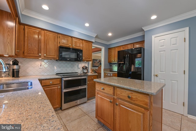 kitchen featuring a center island, brown cabinets, a sink, backsplash, and black appliances