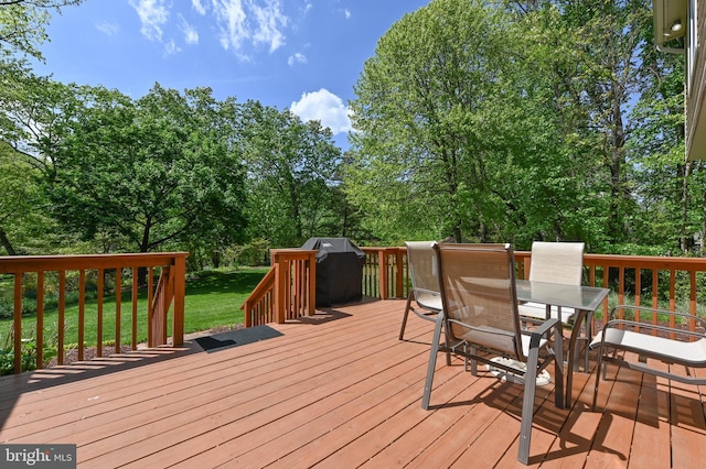 wooden deck with a yard and outdoor dining area