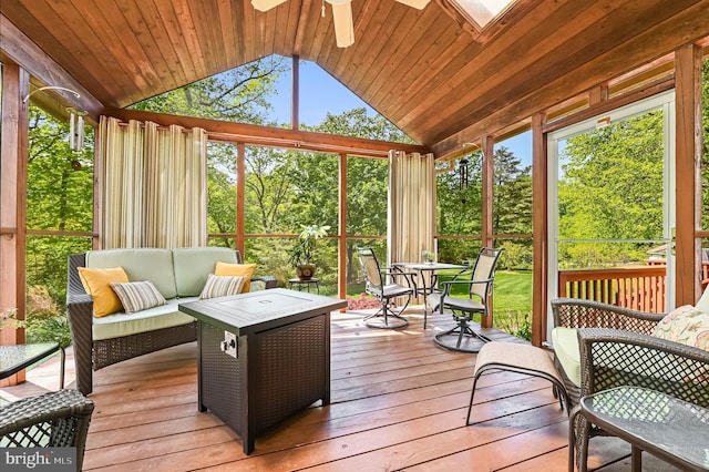 sunroom featuring ceiling fan, an outdoor living space, and outdoor dining area