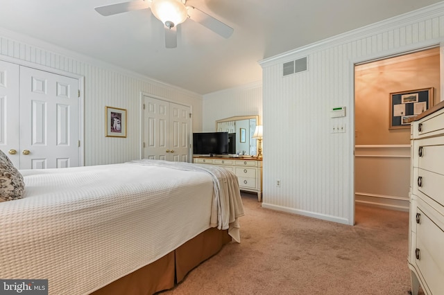bedroom with crown molding, light carpet, multiple closets, baseboards, and visible vents