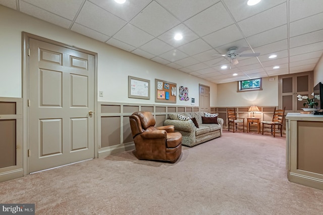 living area featuring carpet floors, a decorative wall, a drop ceiling, recessed lighting, and a ceiling fan