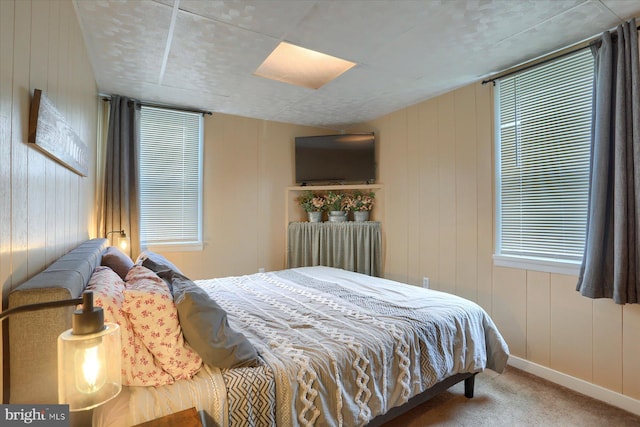 bedroom featuring wood walls, radiator heating unit, and carpet