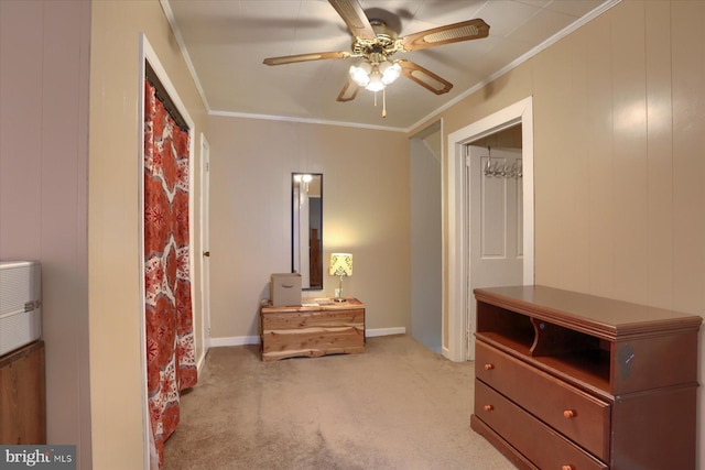 bedroom featuring light colored carpet, ornamental molding, baseboards, and a ceiling fan