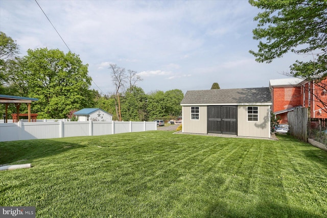 view of yard featuring fence, an outbuilding, and a storage shed