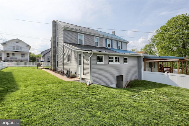 back of house with a yard, fence, and metal roof